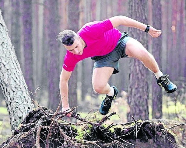 Bloto, bagna, korzenie, powalone drzewa, strumyki to tylko nieliczne z przeszkód na trasie ekstremalnego biegu dożynkowego w Szczańcu. Na zdjęciu: trener personalny Damian Marciniak prowadzi rozgrzewkę przed biegiem