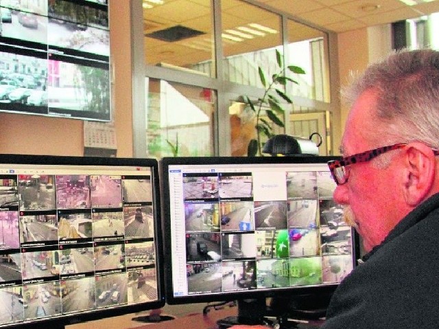 Jarosław Telka ze Straży Miejskiej ogląda widok z miejskich  kamer zamontowanych na ulicach.