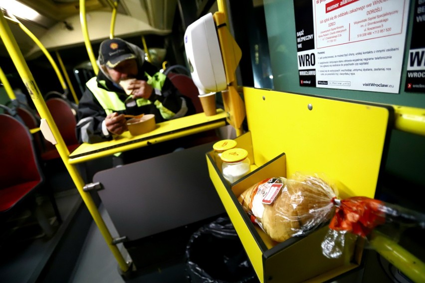 Bezdomni zjedzą w autobusie gorący posiłek