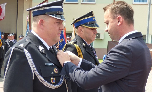 Rafał Paradziej (z lewej) i Zbigniew Dziurewicz otrzymali z rąk posła Michała Cieślaka resortowe odznaki "Zasłużony dla ochrony przeciwpożarowej".