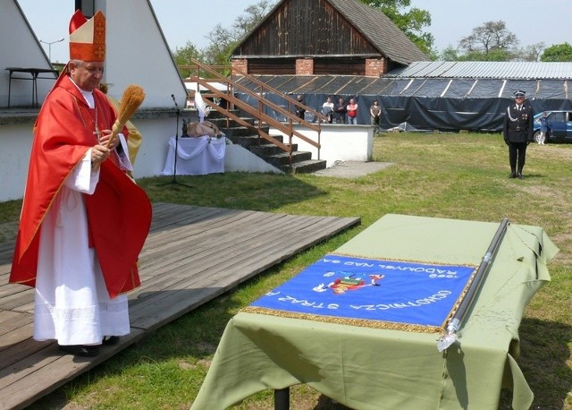 Biskup Jan Ozga poświęca sztandar radomyskich strażaków.