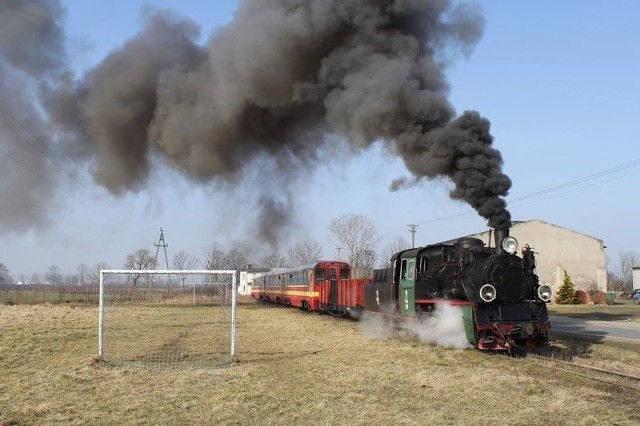 Parowóz Gnieźnieńskiej Kolei Wąskotorowej z pociągiem specjalnym przejeżdża przez boisko we wsi Miroszka