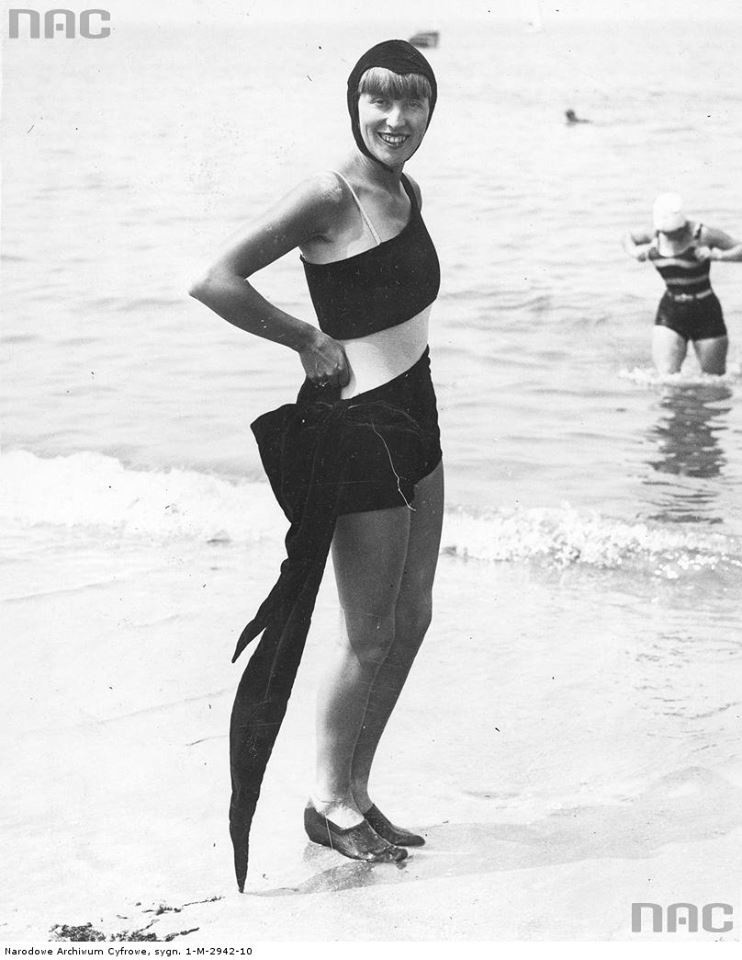 Kobieta na plaży w welwetowym kostiumie kąpielowym z kokardą...
