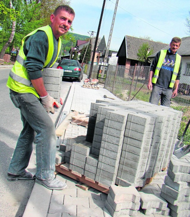 Robotnicy układają chodniki z kostki betonowej wzdłuż głównej drogi przez Łukowicę. Granitowe będą tylko w centrum