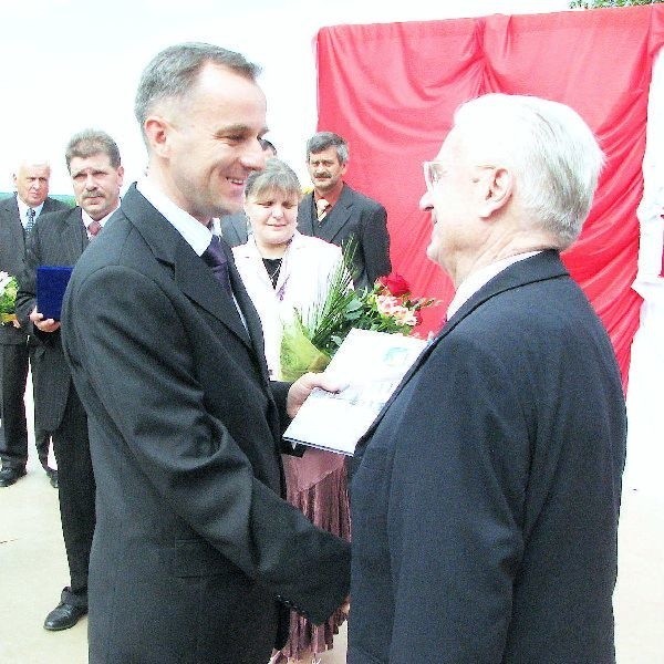 Na zdjęciu Henryk Kulczyk odbiera od  burmistrza Waldemara Stupałkowskiego akt  nadania honorowego obywatelstwa Wałdowa. W  tle rada sołecka.