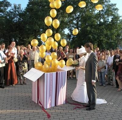 Baloniki wylatujące z prezentu-niespodzianki to pomysł na atrakcyjne wyjście pary młodej z kościoła