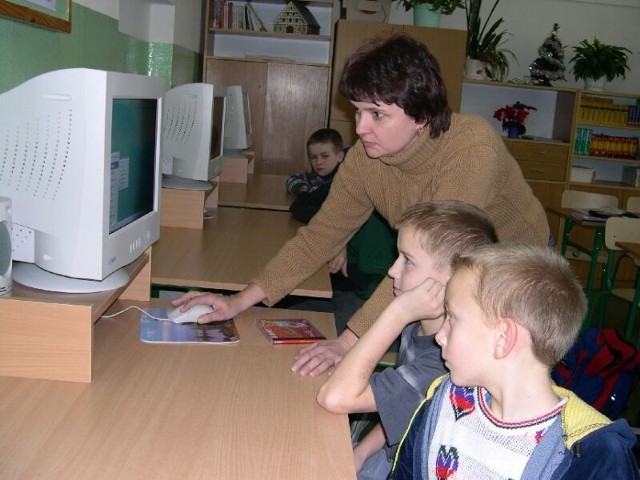 Patryk Śmiejczak (pierwszy z lewej) i Tomek Luc słuchają instrukcji nauczycielki, jak należy korzystać ze sprzętu.