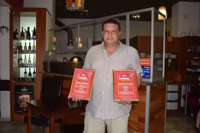 Borys Matusiak, współwłaściciel pizzerii La Favorita z dwoma dyplomami z naszego plebiscytu dla swojego lokalu.