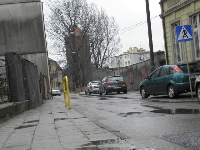 Ul. Tylna w Brodnicy. Po deszczu dokładnie widać nierówność na jezdni i chodniku. Woda stoi w wielu miejscach.