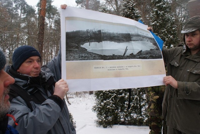 Uczestnicy jednej z poprzednich wypraw do DAG Fabrik prezentują zdjęcie ze skutkami wybuchu trotylu w 1952 roku