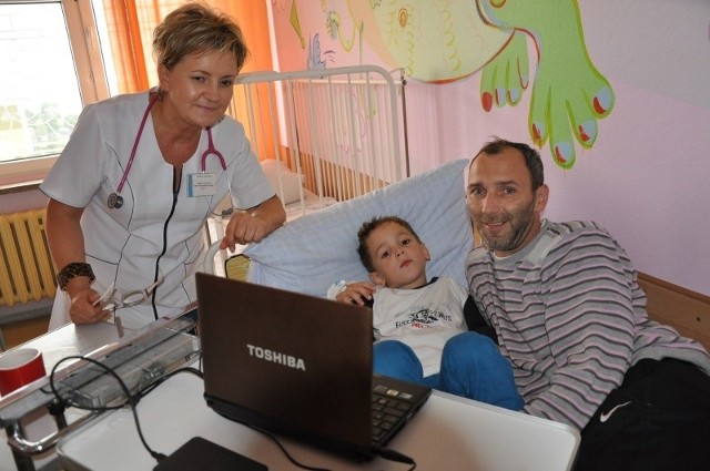 Na zdjęciu: 6-letni Bruno Poniatowski z wujkiem Cezarym i dr Ewą Ladrą-Wieczorek, zastępcą ordynatora pediatrii szpitala w Oleśnie. - Dla dzieci to ważne, że mogą oglądać bajki w komputerze, a na dodatek stale przebywa z nimi ktoś bliski - mówi wujek chłopczyka.
