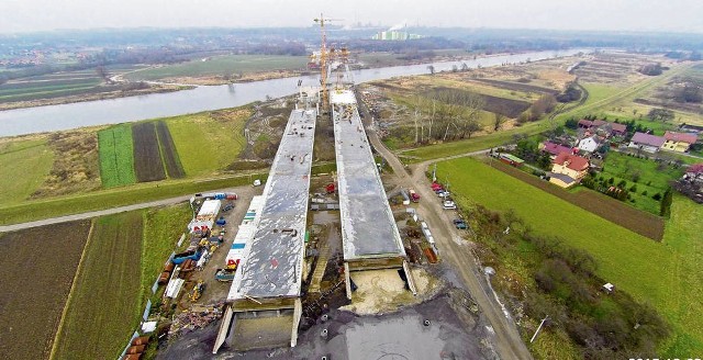 W ramach budowy wschodniej obwodnicy powstają dwa równoległe mosty przez Wisłę o długości 700 metrów (widoczne na pierwszym planie). Po drugiej stronie Wisły (w tle po prawej stronie) widać działającą już spalarnię odpadów przy ul. Giedroycia. Łączy się ona z ul. Igołomską, która jest rozbudowywana i będzie osią dla Nowej Huty Przyszłości