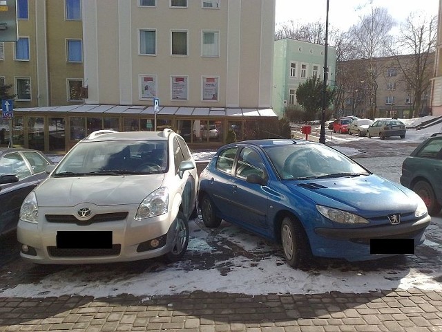 Jeden peugeot zajmujący dwa miejsca parkingowe.