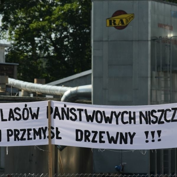 Ten transparent wisi na ogrodzeniu firmy Ra-Kom w Czarnej Białostockiej. Chociaż skojarzenia nasuwają się same, nie ma on związku z aferą w sprawie sprzedaży drewna spółce przez Lasy Państwowe. To pozostałość po proteście drzewiarzy w stolicy z 16 lipca. Pikietowali wtedy przeciwko wysokim cenom drewna, które według nich dyktują Lasy.