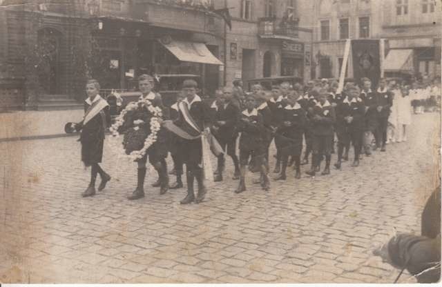 Zdjęcie z lat międzywojennych. Dzieci maszerują przez Rynek Staromiejski mijając zaparkowane koło poczty taksówki (widoczne w tle z lewej strony) Fot.: Archiwum