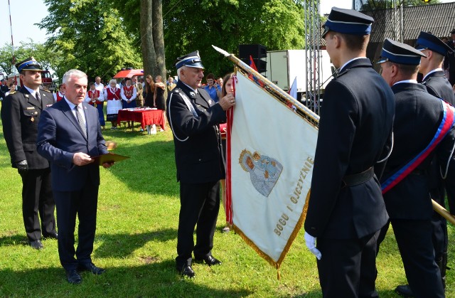 Mirosław Pawlak dekoruje sztandar 100-letniej jednostki strażackiej z Dzierzgowa Złotym Znakiem Związku OSP RP.