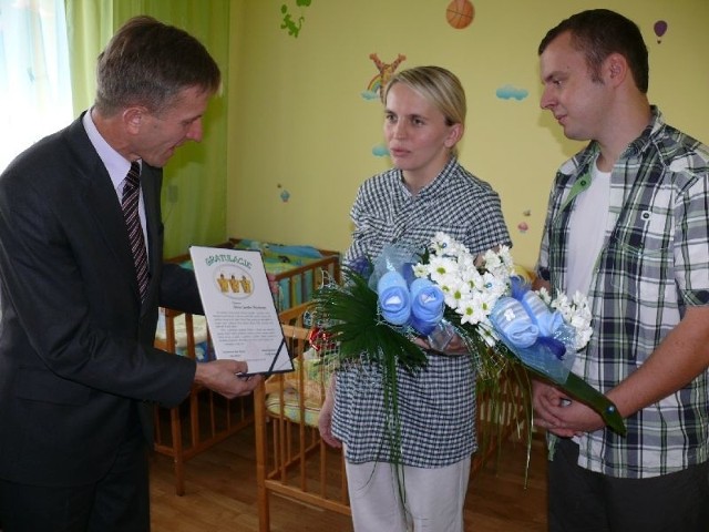 Wacław Szarek, burmistrz Sędziszowa przekazuje rodzicom list gratulacyjny.