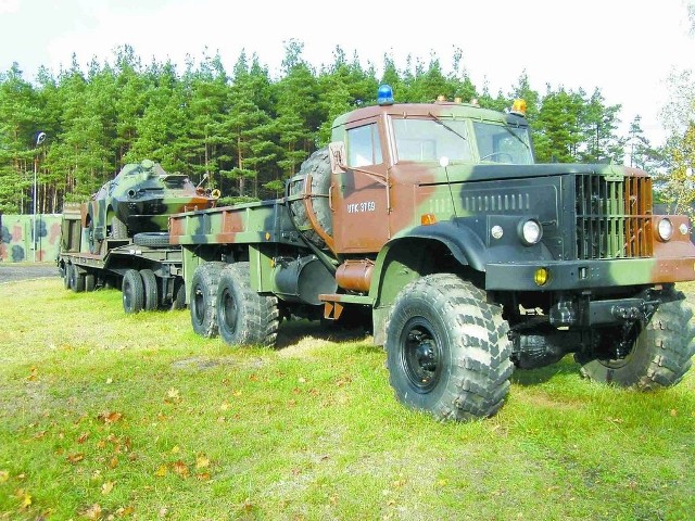 Potężny ciągnik kołowy produkcji sowieckiej Kraz z przyczepą, a na niej BRDM, czyli bojowy transporter opancerzony.