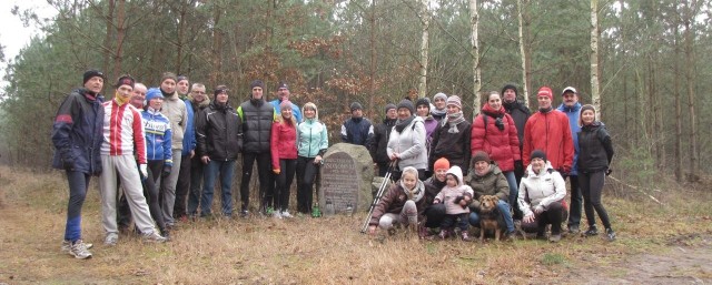 Pamiątkowe zdjęcie uczestników spotkania w Sławnie przy kamieniu upamiętniającym zmarłego trenera Mieczysława Ksokowskiego. 