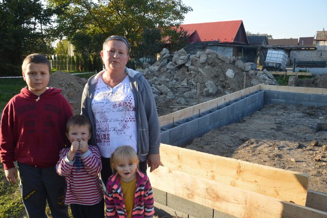 Pani Grażyna z trójką swoich dzieci: 3-letnią Madzią, 5-letnim Mateuszkiem oraz 11-letnim Kacprem. Siedzą w miejscu, gdzie powstaje ich nowy dom w Borzęcinie. Są bardzo szczęśliwi