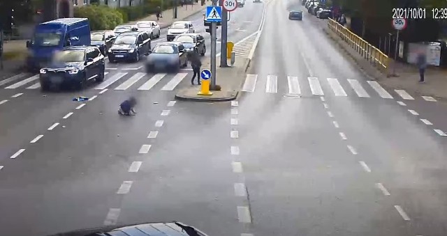 Do bardzo niebezpiecznego zdarzenia z udziałem dziecka doszło na jednej z ulic Olsztyna. Na przejściu dla pieszych została potrącona 10-letnia dziewczynka. Policja ku przestrodze opublikowała film, który został zarejestrowany przez kamerę.Policja ustaliła, że kierowca BMW w tym przypadku nie zawinił. Na nagraniu widać, jak 10-letnia dziewczynka stoi na wyspie rozdzielającej jezdnie. Policja ustaliła, że dzieci zamiast poczekać na zielone światło, postanawiają przebiec przez przejście na czerwonym. Na filmie widać, jak dwie dziewczynki wbiegają wprost pod nadjeżdżające BMW. Kierowca auta nie był wstanie wyhamować, gdyż dzieci wybiegły zza stojącej na lewym pasie kolumnie aut. Jedna z dziewczynek została potrącona, odbiła się od auta i upadała. ZOBACZ WIDEO - KLIKNIJ DALEJ