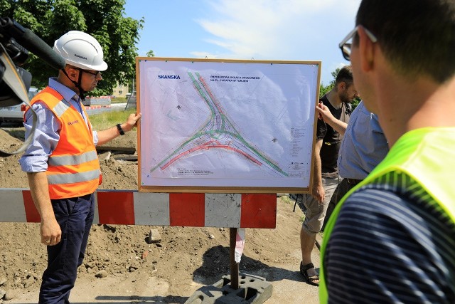 W Toruniu trwa przebudowa placu Chrapka. Od najbliższego wtorku (29 maja) na kierowców czekają kolejne zmiany w organizacji ruchu. Na ulicy Warneńczyka jeden pas zostanie wyłączony z ruchu.Główny front robót na placu Chrapka w Toruniu obejmuje obecnie południową jezdnię ul. Przy Kaszowniku. Na wyłączonej z ruchu jezdni wykonano już roboty rozbiórkowe, przebudowano kolizje energetyczne i teletechniczne, zrobiono także dolne warstwy konstrukcyjne jezdni. Na wlocie zachodnim ronda ustawiono krawężniki.Równolegle na wylocie w kierunku placu Pokoju Toruńskiego trwają prace związane z budową kolektora deszczowego. Po jego wybudowaniu rozpoczną się w tym miejscu roboty drogowe. Trwa układanie kabla, który zasili nową sieć trakcji tramwajowej.- W związku z pracami na południowej jezdni ulicy Przy Kaszowniku, ruch dwukierunkowy odbywa się jezdnię północną, czyli tą od strony cmentarza. Na wysokości sklepu Netto przejeżdżamy przez torowisko, specjalnie przygotowanym przejazdem przez torowisko. Dla zapewnienia bezpieczeństwa w tym miejscu została zamontowana sygnalizacja świetlna. Na skrzyżowaniu placu Chrapka została utrzymana relacja z pierwszeństwem z Bydgoszczy w kierunku Gdańska. Przystanek autobusowy Przy Kaszowniku został przeniesiony z jezdni zachodniej na jezdnię wschodnią. Dojście do przystanku jest możliwe tymczasowym przejściem dla pieszych od strony wschodniej ulicy Przy Kaszowniku – informuje Agnieszka Kobus-Pęńsko, rzecznik MZD w Toruniu.Od wtorku 29 maja front robót poszerzy się o roboty rozbiórkowe na ulicy Warneńczyka (wylot na Gdańsk). Jezdnia zostanie ograniczona do jednego pasa ruchu do wysokości przystanku autobusowego. Z uwagi na bezpieczeństwo zwężony zostanie również chodnik wzdłuż ulicy.Przebudowa placu Chrapka trwać ma do 26 marca 2019 roku. Prace, realizowane z unijnym dofinansowaniem, kosztują 20 095 671,40 zł.Wideo: Info z Polski 24.05.2018