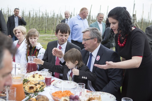 Przy stole w sadzie. Bronisław Komorowski w towarzystwie Moniki i Tomasza Bankiewiczów, na kolanach prezydenta najmłodsza pociecha rodziny sadowników - 6-letni Jaś.