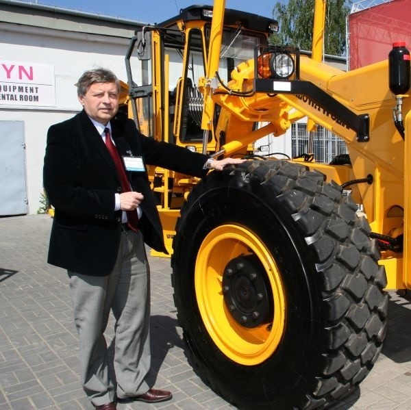 Krzysztof Madziński szef firmy Miasta ze Stalowej Woli pokazuje najnowszy typ równiarki drogowej.
