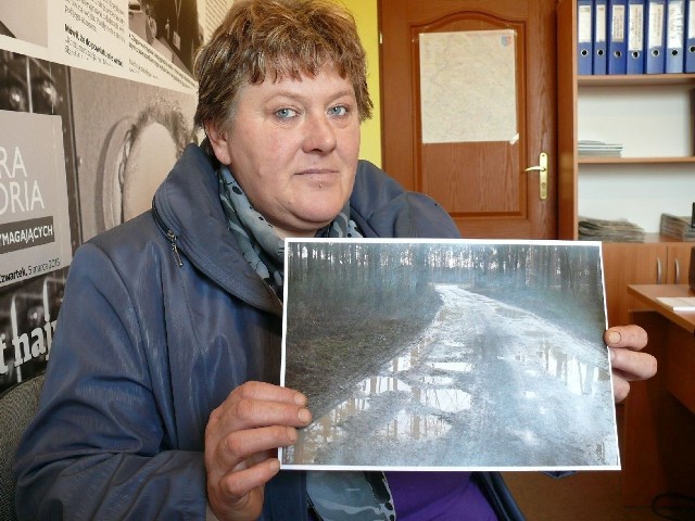 Renata Łączek z Dąbrów w gminie Kluczewsko pokazuje zdjęcie zaniedbanej drogi do swojej miejscowości.