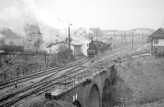 Przepiękne unikalne zdjęcie z końca lat 90. XX wieku &#8211; Ty2 z pociągiem zbiorowym do Kościerzyny wyjeżdża z Bytowa, w tle widoczna lokomotywa ST44 od pociągu zbiorowego Słupsk &#8211; Bytów &#8211; Słupsk. Były to, niestety, ostatnie lata świetności bytowskiej stacji. Zdjęcie autorstwa Jurgena Courta pochodzi z książki "Dampfbahnen in Polen&#8221;.