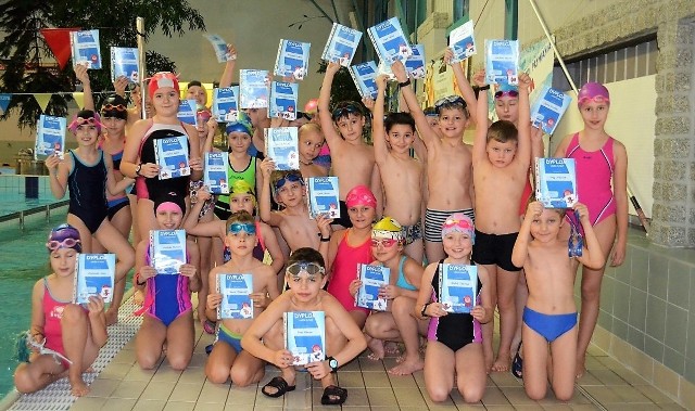 Dzieci z oświęcimskiej Szkoły Podstawowej nr 11 prezentują dyplomy ukończenia podstawowej nauki pływania.