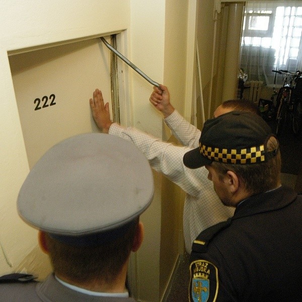 Komornik w asyście policjanta i strażnika miejskiego wyważa drzwi jednego z opolskich mieszkań. Podobnych interwencji jest ostatnio mniej, bo dłużników nie ma dokąd przenieść.