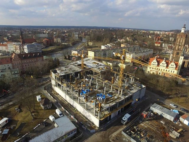 Przedstawiciele firmy Hosso, która buduje galerię handlową w centrum Gubina, potwierdzili, że wewnątrz obiektu będzie znajdować się nowoczesny klub fitness. A co poza tym?Rzecznik firmy Hosso, Katarzyna Meger-Dziechciarz przyznaje, że pogoda dopisuje i dzięki temu budowa galerii handlowej idzie pełną parą. - Ponad 120 pracowników każdego dnia zmienia oblicze budowli - przyznaje przedstawicielka inwestora. - Otwarcie galerii zaplanowane jest w drugiej połowie bieżącego roku. Już teraz mogę zdradzić, że wśród sklepów znajdą się między innymi marki związane z modą, a także sportowe, obuwie, elektronika, punkty usługowe. O zdrowie i kondycję fizyczną mieszkańców Gubina i Guben zadba bogato wyposażone studio fitness, natomiast najmłodsi spędzą czas w baśniowym placu zabaw. Przykładamy dużą uwagę również do oferty gastronomicznej. Znajdzie się tu kawiarnia, a także kuchnia polska oraz bliskowschodnie smaki.Przeczytaj też:  Nowa galeria w Żaganiu prawie gotowa. Kiedy otwarcie? [ZDJĘCIA] Zobacz też wideo: Magazyn Informacyjny GL 16.03.2018