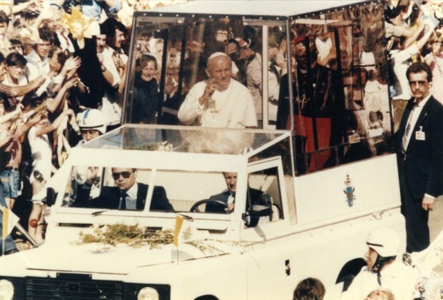 Jan Paweł II i metropolita krakowski kardynał Franciszek Macharski jadą ulicą Krakowa w papamobile pozdrawiając zebranych wzdłuż ulicy wiernych. 22 VI 1983 r. Sygnatura: IPNBU-7-14-8-1