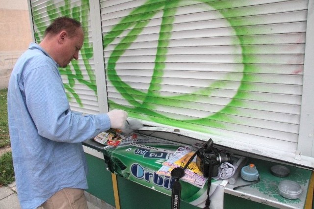 Policyjny technik zabezpiecza ślady po włamaniu do kiosku przy ulicy Toporowskiego w Kielcach.