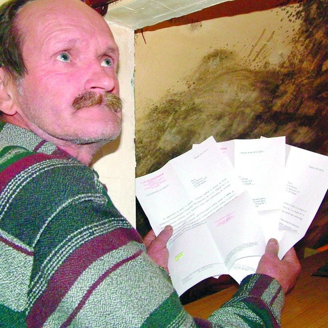 Andrzej Wyrwa przy zniszczonym pokoju z plikiem korespondencji z PGM.