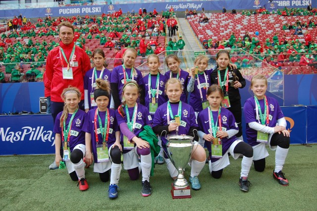 Piłkarki inowrocławskiej Szóstki z dumą prezentują efektowne trofeum, które zdobyły w Warszawie.