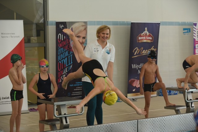 Ponad tysiąc młodych adeptów pływania wzięło w tym roku udział w cyklu zajęć Otylia Swim Tour. Ostatni odcinek projektu odbył się w sobotę w Toruniu, gdzie w sali gimnastycznej i na pływalni ćwiczyło blisko 150 dzieci.W sumie w 2018 roku w zajęciach zorganizowanych w ramach projektu Otylia Swim Tour w sześciu miastach – Chorzowie, Nowym Sączu, Nowym Targu, Krakowie, Łodzi i Toruniu – udział wzięło ponad tysiąc dzieci.ZOBACZCIE ZDJĘCIA Z TORUŃSKIEJ PŁYWALNI >>>– Te liczby robią wrażenie, bo to jest ponad tysiąc młodych adeptów pływania i prawie dwa tysiące rodziców. Jestem bardzo zadowolona, że ten projekt tak się rozwinął, że jest duże zainteresowanie i miast, które chcą nas gościć, i dzieci, które chcą ćwiczyć. Jestem dumna z naszych działań w 2018 roku, oczywiście w ramach Otylia Swim Tour, bo to nie jest jeszcze koniec naszych projektów w tym roku – mówiła Otylia Jędrzejczak.Uczestnicy toruńskiej imprezy nie ukrywali, że uwielbiają pływać. – Ja mam codziennie treningi, bo chodzę do klasy sportowej, a oprócz tego chodzę jeszcze na zajęcia dodatkowe. Mój tata wiele opowiadał mi o Otylii, jak startowała, jakim stylem pływała. Wiem, że była mistrzynią olimpijską, mistrzynią świata i mistrzynią Europy – mówił Igor, jeden z młodych adeptów pływania, którzy ćwiczyli w Toruniu.Zajęcia odbywały się na obiektach Uniwersyteckiego Centrum Sportowego w Toruniu, a dzieci, poza bardzo ciekawymi zajęciami, dostały też bogate pakiety ufundowane przez Fundację Otylii Jędrzejczak oraz jej partnerów, m.in. firmy Marwit, BelVita i Jurajska. Projekt finansowany jest przez Ministerstwo Sportu i Turystyki, a impreza w Toruniu współfinansowana była ze środków Miasta Toruń.