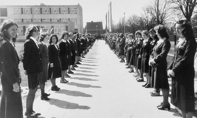 Rok 1974, uczennice w mundurkach szkolnych stoją w szpalerze wiodącym do nowej siedziby, którą wybudowano przy ówczesnej ulicy Mariana Buczka, dziś Szczecińskiej.
