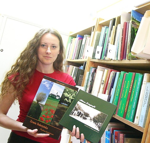 Na zdjęciu: stażystka biblioteki Alicja Bieńkowska prezentuje albumy fotograficzne. 