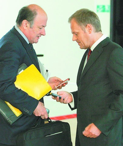 Premier Tusk i minister Rostowski wyłączają telefony komórkowe przed posiedzeniem rządu dotyczącego przyjęcia pakietu antykryzysowego