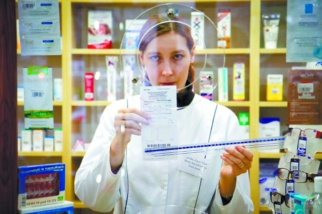 Beata Aszurkiewicz z apteki Aqua Vitae w Białymstoku sprawdza linijką czy recepta ma odpowiednie wymiary (9-11 na 20-21,5 cm)