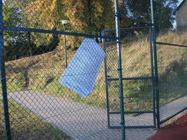 Zniszczona tablica z regulaminem boiska