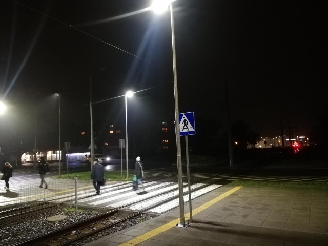 Rozświetlone przejścia dla pieszych przy Wojska Polskiego w rejonie skrzyżowania z ul. Baczyńskiego, a dalej strefa mroku (również na pozostałych przejściach).