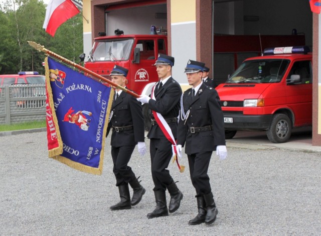 Na zdjęciach strażacy z Nowosielca podczas przekazania sztandaru dla ich jednostki. W garażach widać samochody, którymi druhowie dysponują obecnie.