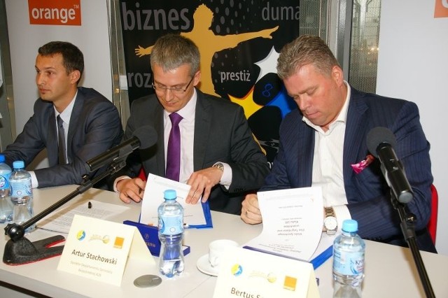 Podpisanie umowy pomiędzy Bertusem Servaasem, prezesem Vive Targi Kielce (z prawej) a Arturem Stachowskim z Orange (w środku)