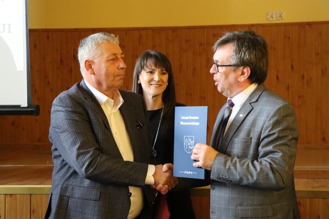 Starosta włoszczowski Dariusz Czechowski (z prawej) przekazuje jeden egzemplarz podpisanej umowy prezesowi firmy Dukt Arturowi Piwowarowi.