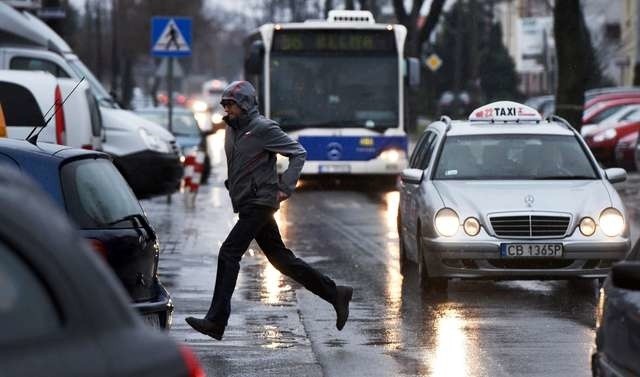 Na ulicy Nakielskiej panuje duży ruch. Niektórzy piesi ratują się sprintem pomiędzy jadącymi samochodami