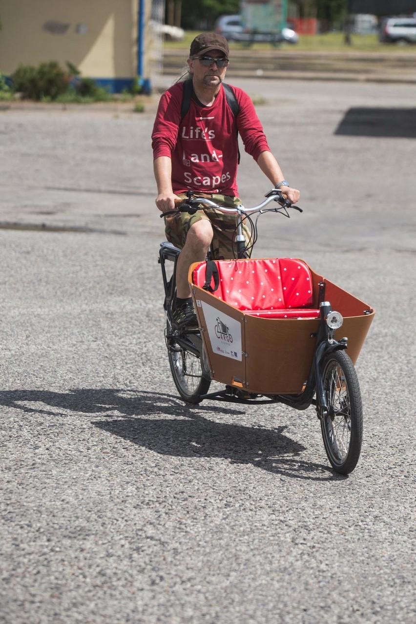 Dwukołowy rower cargo Babboe City-E ma otwartą drewnianą...