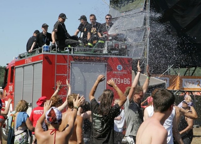 Strażacy ochotnicy z Witnicy polewają wodą rozgrzany tłum pod sceną.